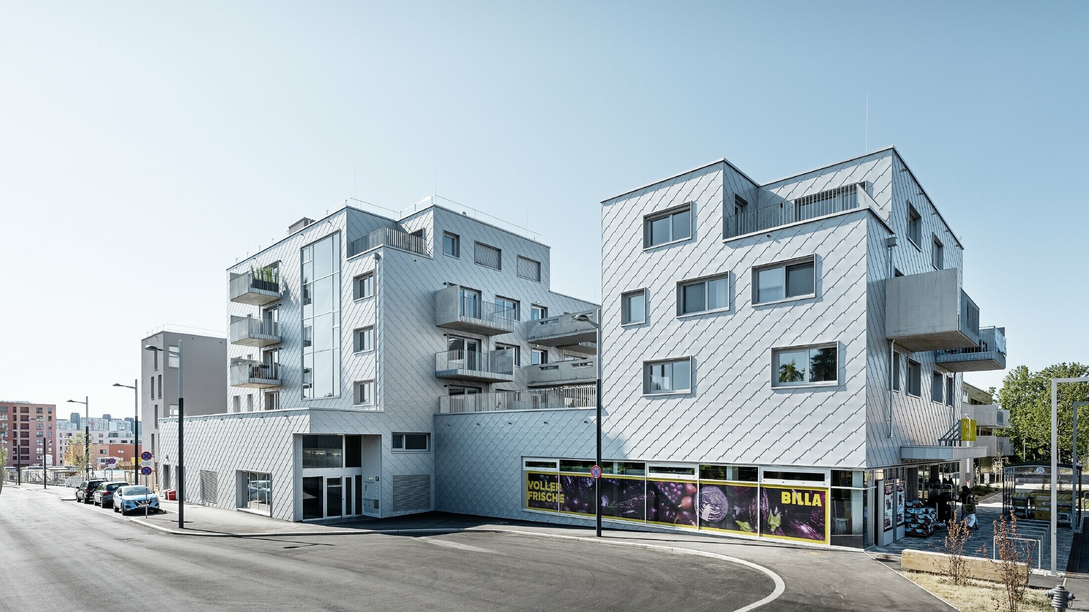 Stambeni kompleksi s ravnim krovom i rombnom oblogom na fasadi s PREFA zidnim rombom 44 × 44 u metalik srebrnoj boji