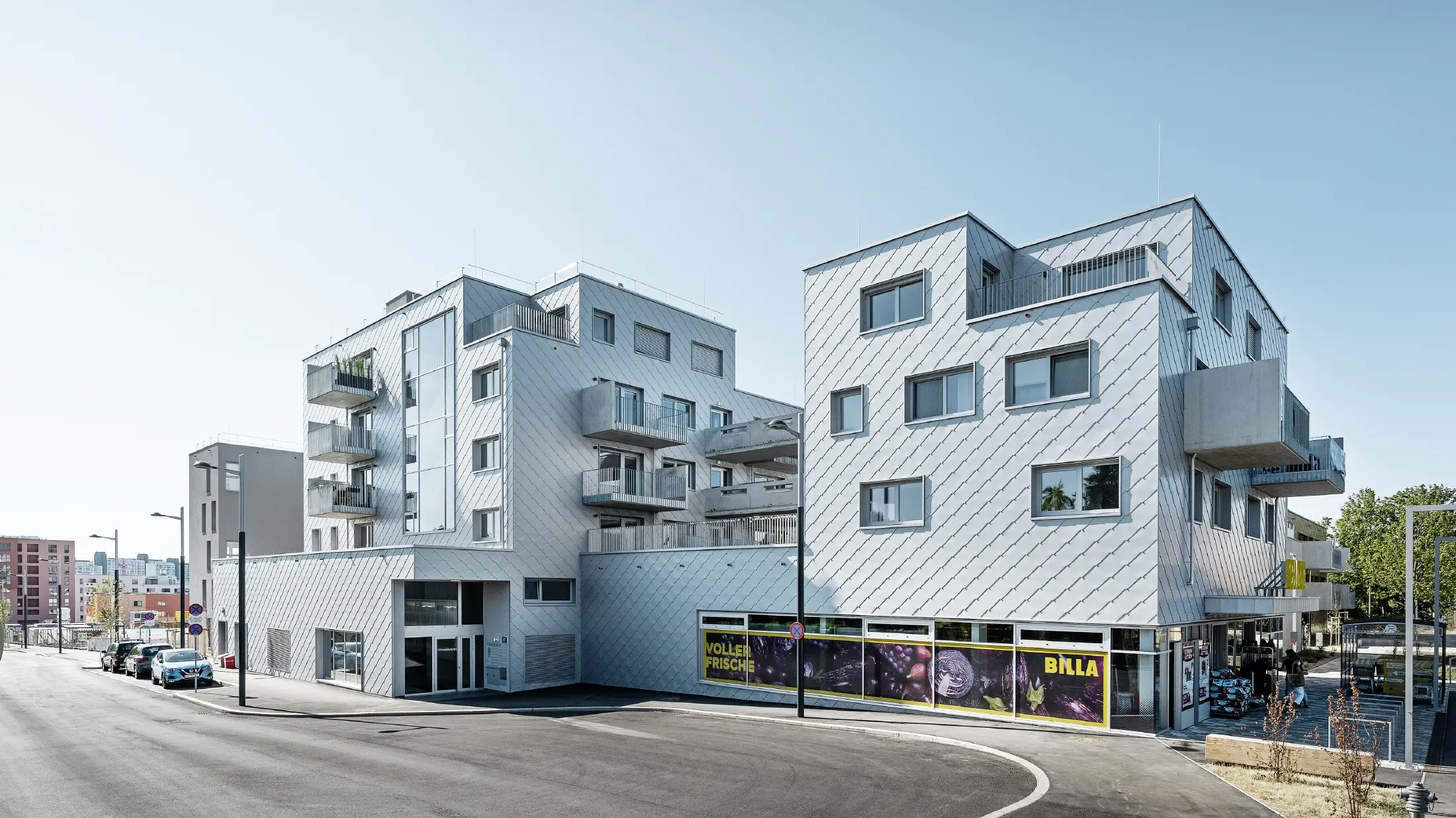 Stambeni kompleksi s ravnim krovom i rombnom oblogom na fasadi s PREFA zidnim rombom 44 × 44 u metalik srebrnoj boji