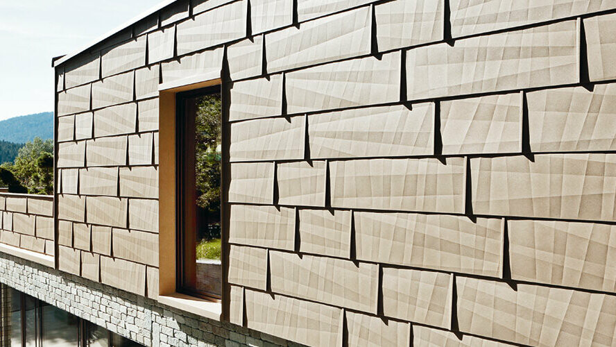 Na ovoj vanjskoj fasadi PREFA fasadni panel FX.12 u P.10 pješčano smeđoj kombiniran je s kamenom fasadom u prizemlju.
