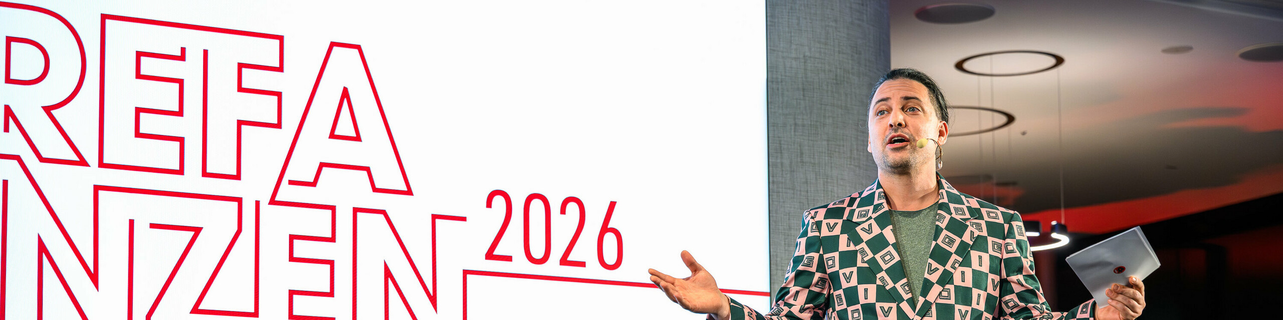 Trenutak na pozornici s wow-efektom na PREFARENZEN prezentaciji 2026.: Moderator Serkan Temel oduševio je publiku svojim šarmom, humorom i upečatljivim outfitom. Njegova prisutnost naglašava kreativan duh događanja, koji spaja inovaciju, dizajn i zajedništvo. Večer za pamćenje u K47.wien, koja pokazuje kako se danas s PREFA aluminijem zamišlja i živi moderna i svestrana arhitektura.