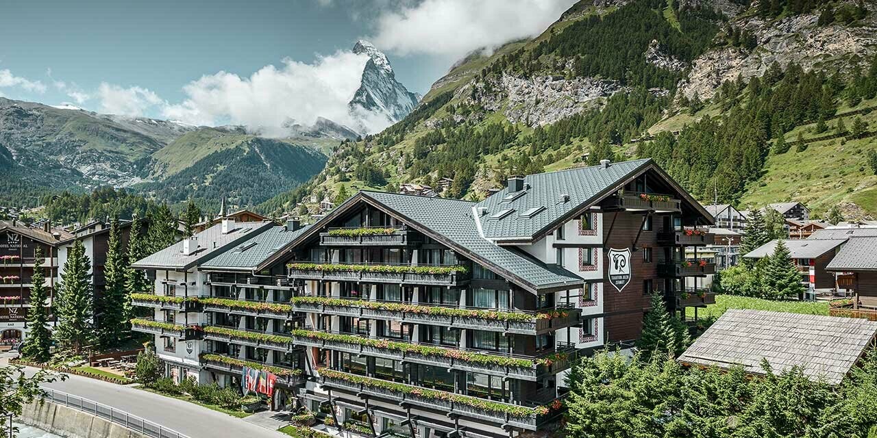 Hotel Alpenhof u Zermattu s Matterhornom u pozadini, tamnom drvenom fasadom i PREFA aluminijskim krovom u antracit boji
