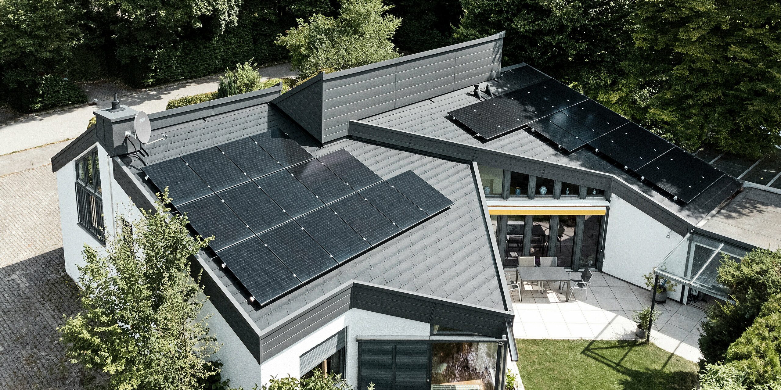 Ein Einfamilienhaus, das mit PREFA Dachschindeln DS.19 in schwarz eingedeckt wurde. Für Teile der Fassade wurden PREFA Sidings in P.10 dunkelgrau verwendet. 