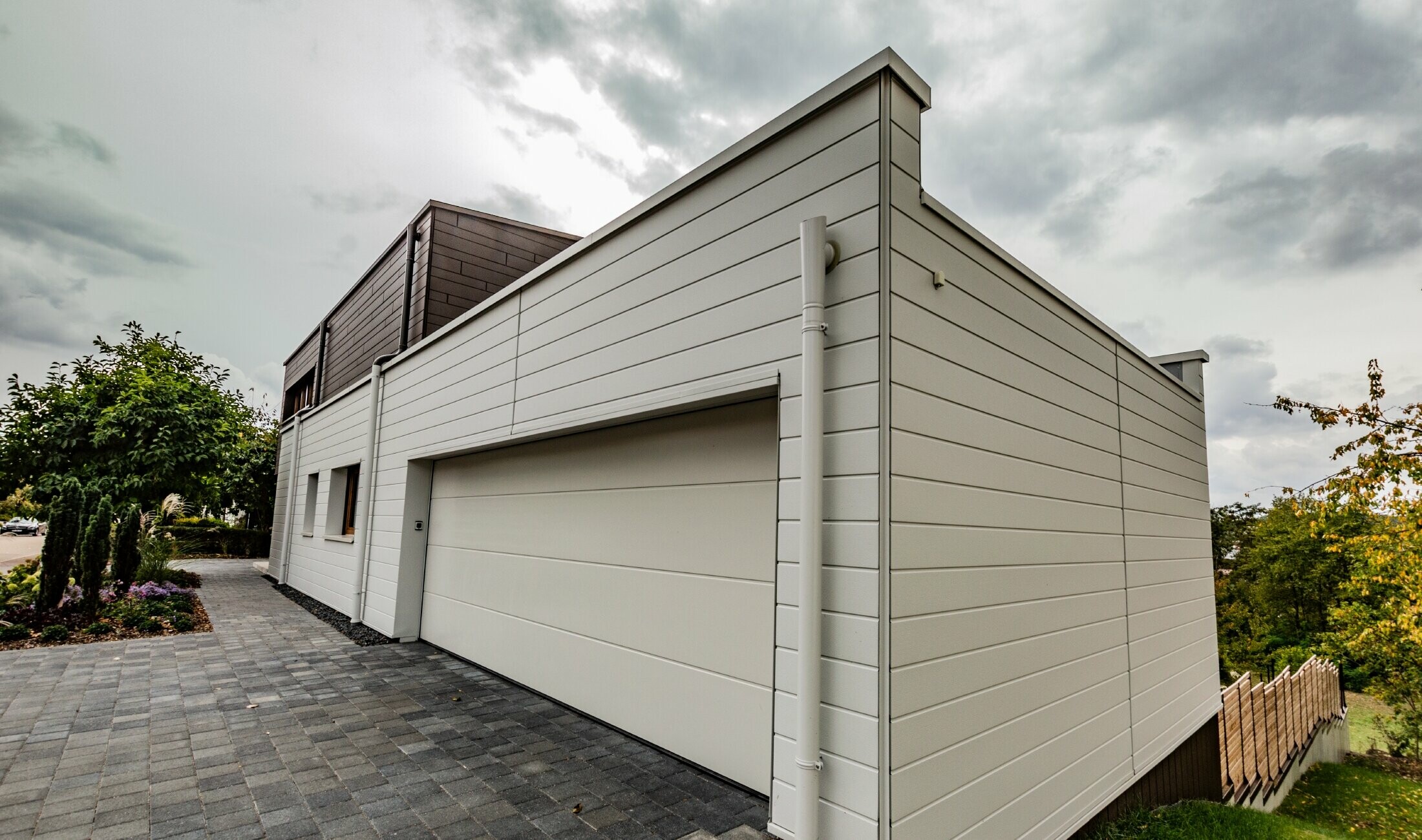 Obloga garaže PREFA kazetom Siding u bijeloj boji horizontalno položenom s PREFA bočnim uljevom.