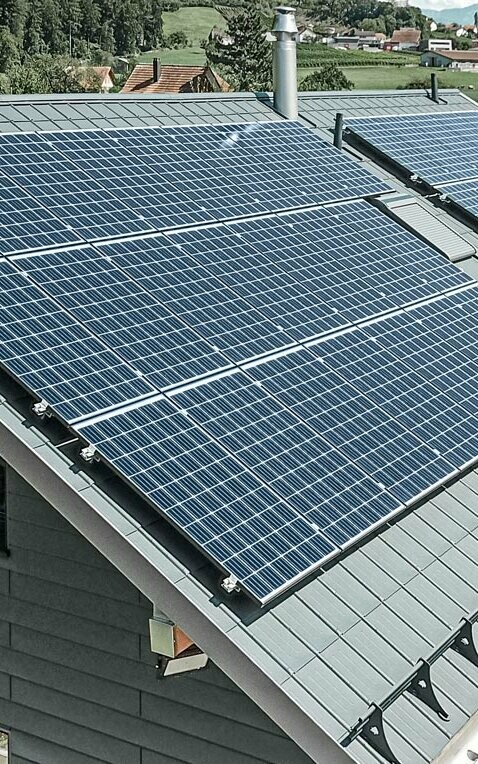 [Translate to Hrvatski:] PREFA Dachplatte in der Farbe anthrazit mit einer montierten Photovoltaik-Anlage als Aufdach-Lösung.