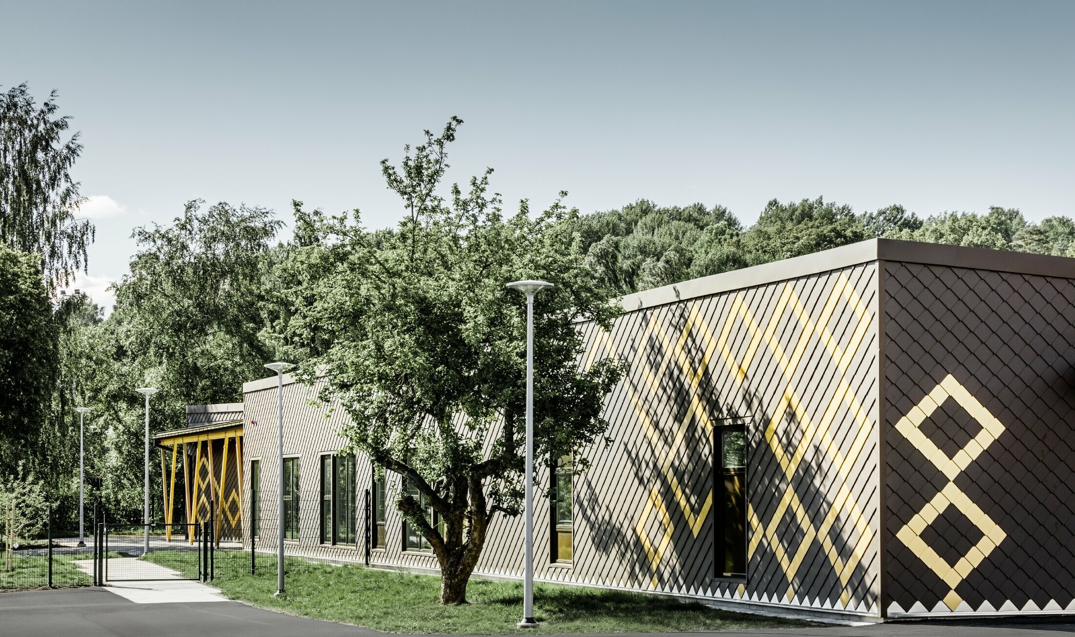 Predškolska ustanova u Stockholmu obložena je robusnom aluminijskom fasadom tvrtke PREFA. Rombovima u smeđoj i mayagold zlatnoj dobiva se zanimljiv uzorak.