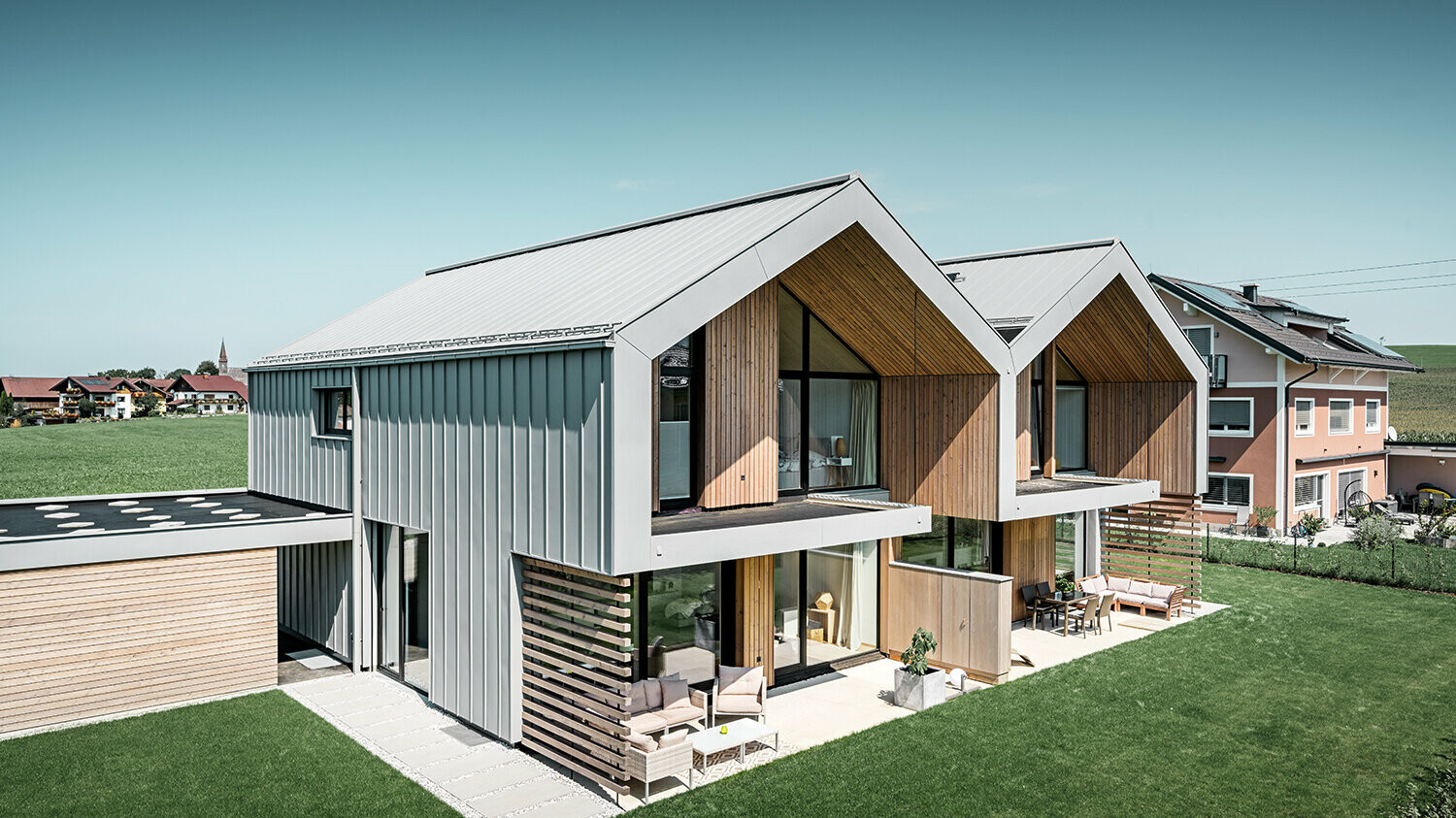 Moderne dvojne kuće s PREFALZ ovojnicom kuće, krov i fasada obloženi su sustavom PREFALZ u patina sivoj boji uklj. kvadratnu cijev