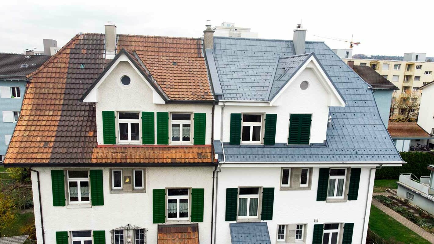 Polovica dvojne kuće u Švicarskoj; Lijeva polovica zgrade još nije sanirana i još je uvijek pokrivena zamrljanim crjepovima. Desna polovica zgrade pokrivena je PREFA krovnim pločama u kameno sivoj.